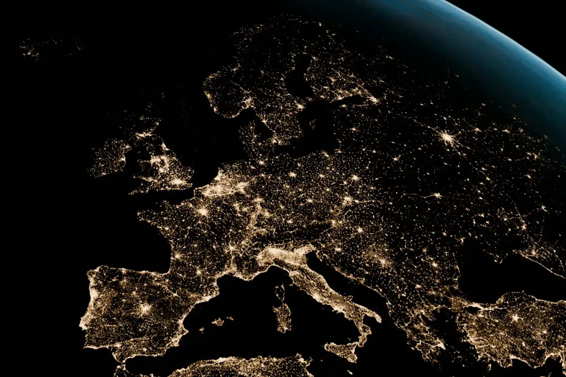 Satellite view of Europe at night with city lights across the UK, France, Germany, Spain, Italy, and the Nordics, symbolizing connected hybrid work.
