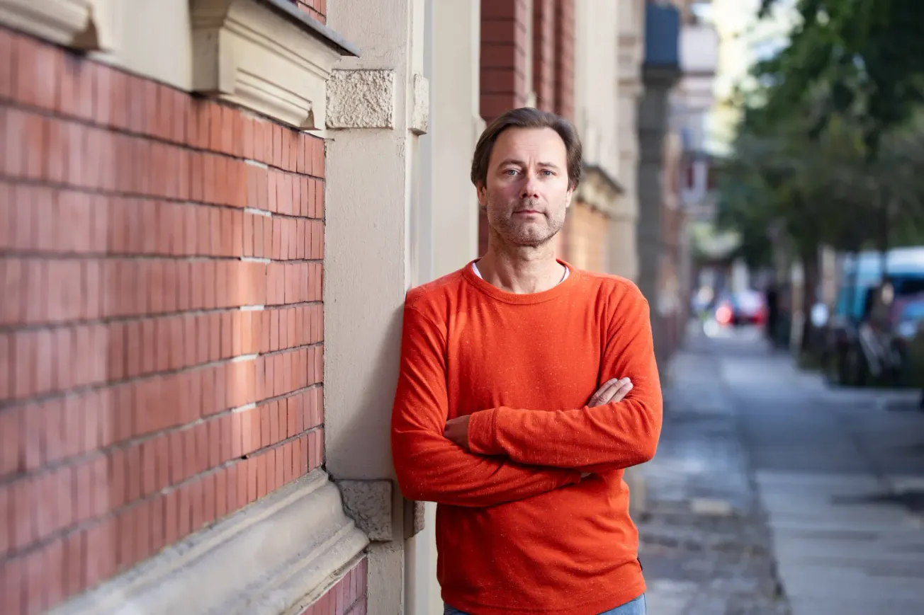 Der Politologe Thomas Biebricher lehnt mit verschränkten Armen an einer Wand. Credit: IMAGO/Emmanuele Contini