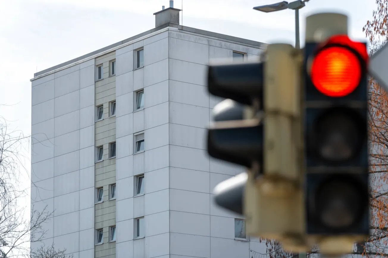 Ein Häuserblock im Hintergrund, im Vordergrund eine Ampel, die rot anzeigt. Credit: IMAGO/Bihlmayerfotografie
