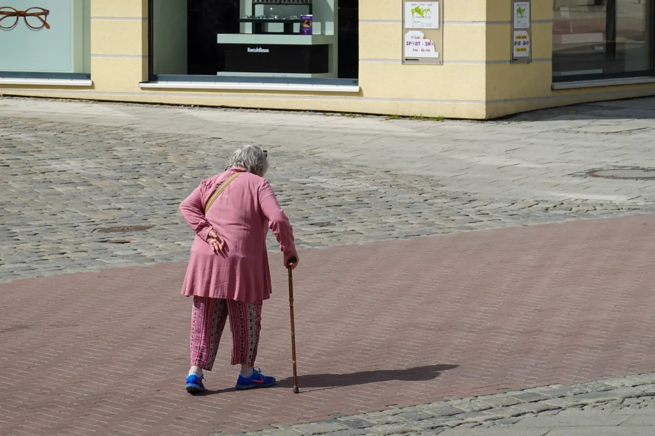 Ältere Frau, die in einer deutschen Innenstadt mit einem Stock geht (Symbolbild). Credit: IMAGO/NurPhoto