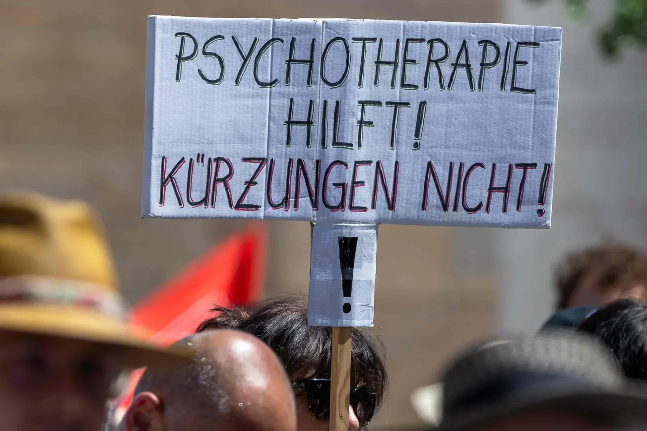 Ein Protestschild mit der Aufschrift »Psychotherapie hilft! Kürzungen nicht!« Credit: IMAGO / Ardan Fuessmann