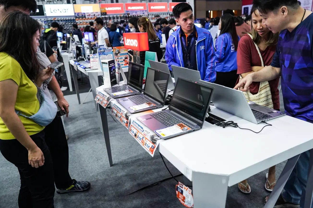 Kundinnen und Kunden schauen sich in einem Geschäft Laptops an. Credit: IMAGO/NurPhoto