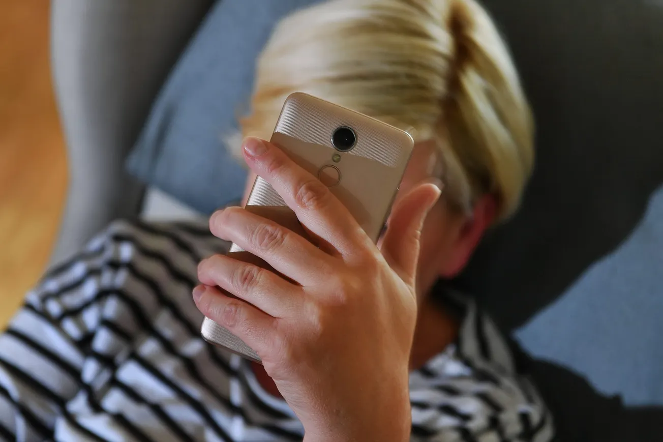 Frau hält ein Smartphone in der Hand (Symbolbild). Credit: IMAGO/Sven Simon