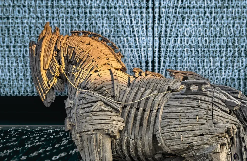 Bildschirm mit Code im Hintergrund, Trojanisches Pferd im Vordergrund. Collage: Surplus, Material: IMAGO/Silas Stein/Zoonar.