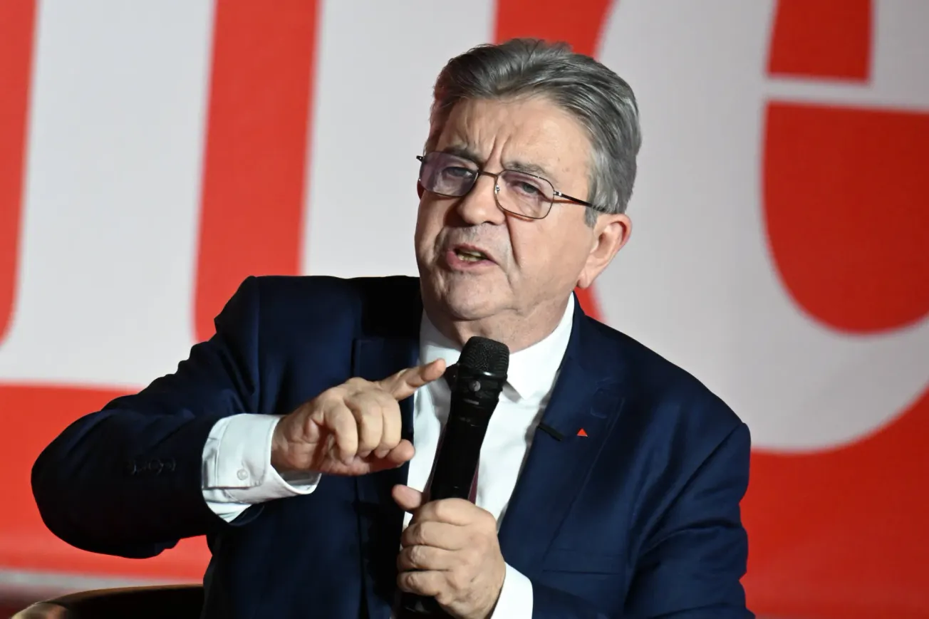 Bild von französischen Präsidentschaftskandidat Jean-Luc Mélenchon, wie er auf einer Bühne sitzt und etwas erklärt.