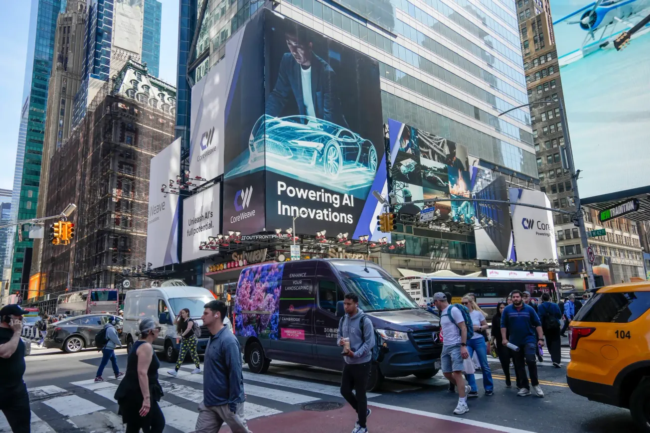 Große Werbeanzeige für CoreWeave in New York, Times Square. Verkehr und Menschenmengen im Vordergrund. Credit: IMAGO/Levine-Roberts.