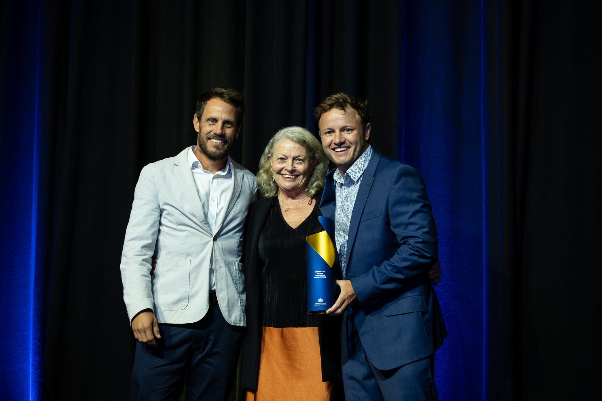 In The Beginning celebrating its Best sport podcast win with the Australian Sports Commission Media Awards trophy.