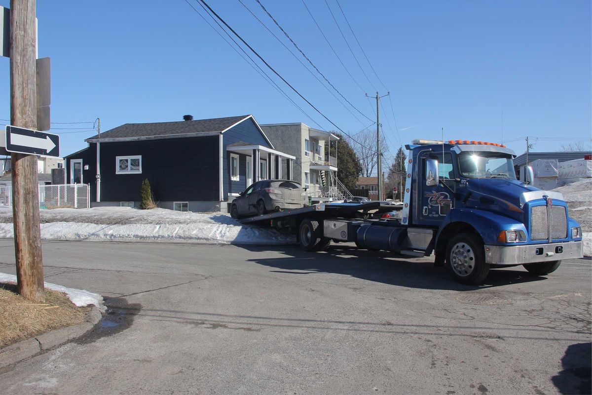 Une voiture qui a monté sur un terrain à la suite d'un accident est remorquée au coin de la 17e rue et de la 14e avenue, à Sa
