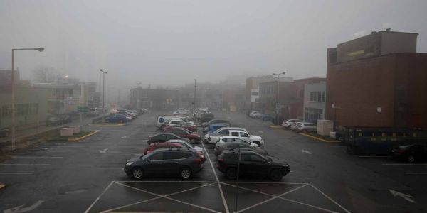 Vue des locaux de la Chambre de commerce et d'industrie de Saint-Jérôme, le stationnement de la rue De Villemure dans la brum