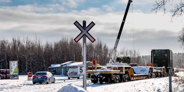 Une grue, deux gros objets verts, un wagon arrêté au quai du boulevard Lajeunesse, à Saint-Jérôme, le 14 janvier 2016.