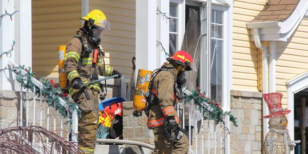Deux pompiers sortent d'une maison de Prévost, sur la rue Bourque, le 29 mars 2016. Photos par Alexandre Parent Léveillé
