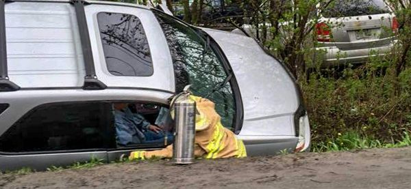 Un pompier et un extincteur sont à côté d'un véhicule qui est arrêté dans le fossé de la montée Masson à Sainte-Sophie, le ve