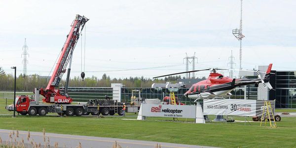 Du brun et blanc, l'hélicoptère devant l'usine de Bell Helicopter à Mirabel est maintenant rouge et blanc. Photo par André Be