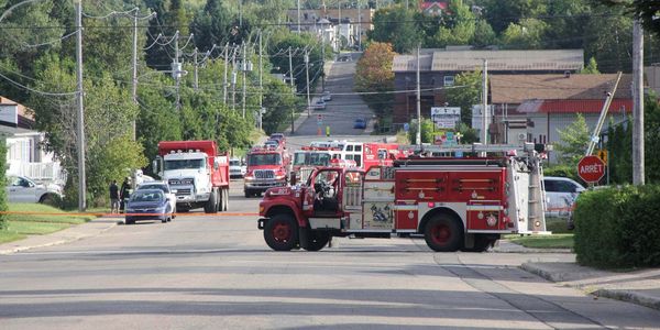 Le poteau victime de la poussée du camion-benne, à droite de l'image, sur la rue Demontigny, le 29 août 2016. Photos par Alex