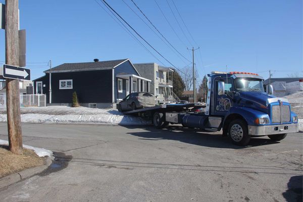 Une voiture qui a monté sur un terrain à la suite d'un accident est remorquée au coin de la 17e rue et de la 14e avenue, à Sa