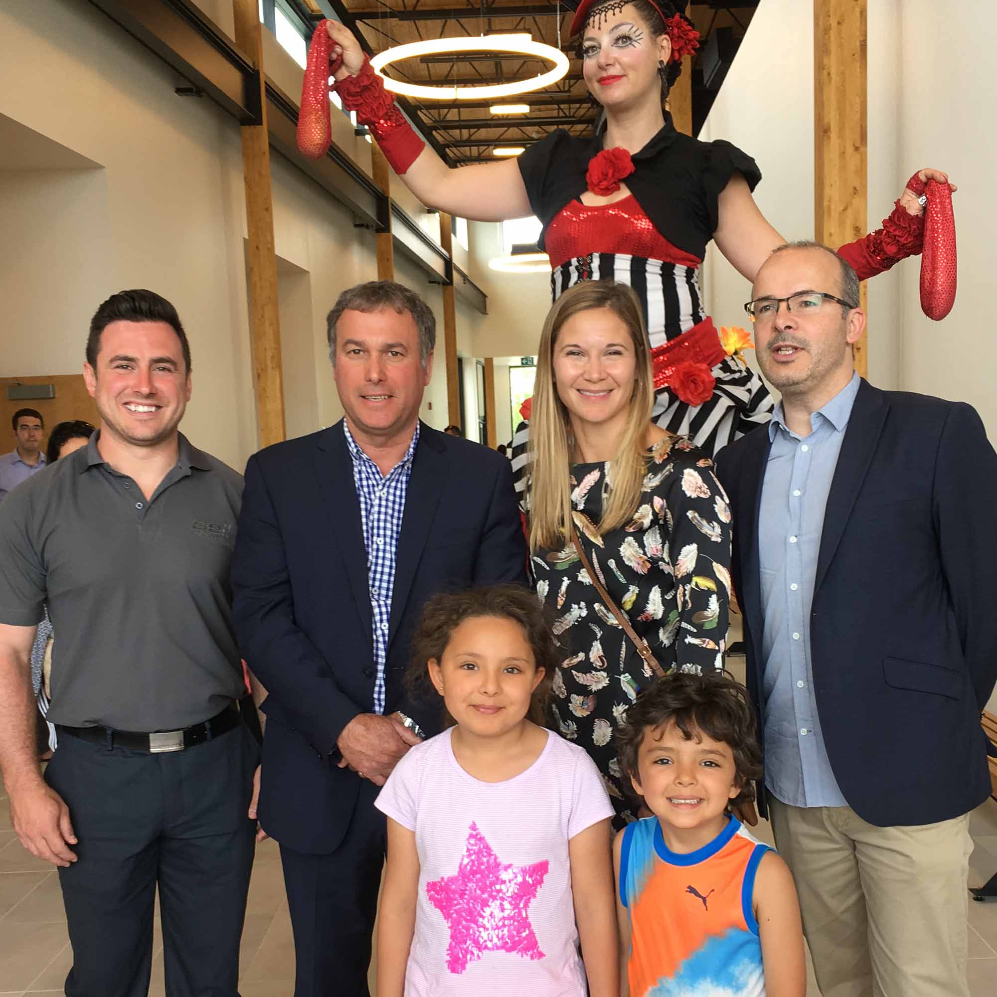 Dans le grand hall, Michael Nault de Bell Helicopter Textron, Jean Bouchard, maire de Mirabel, Isabelle Nuckle d’Hydro-Québec et Martin Brière, architecte et concepteur pour la firme BGLA, posent fièrement avec les enfants et une dame aux échasses.