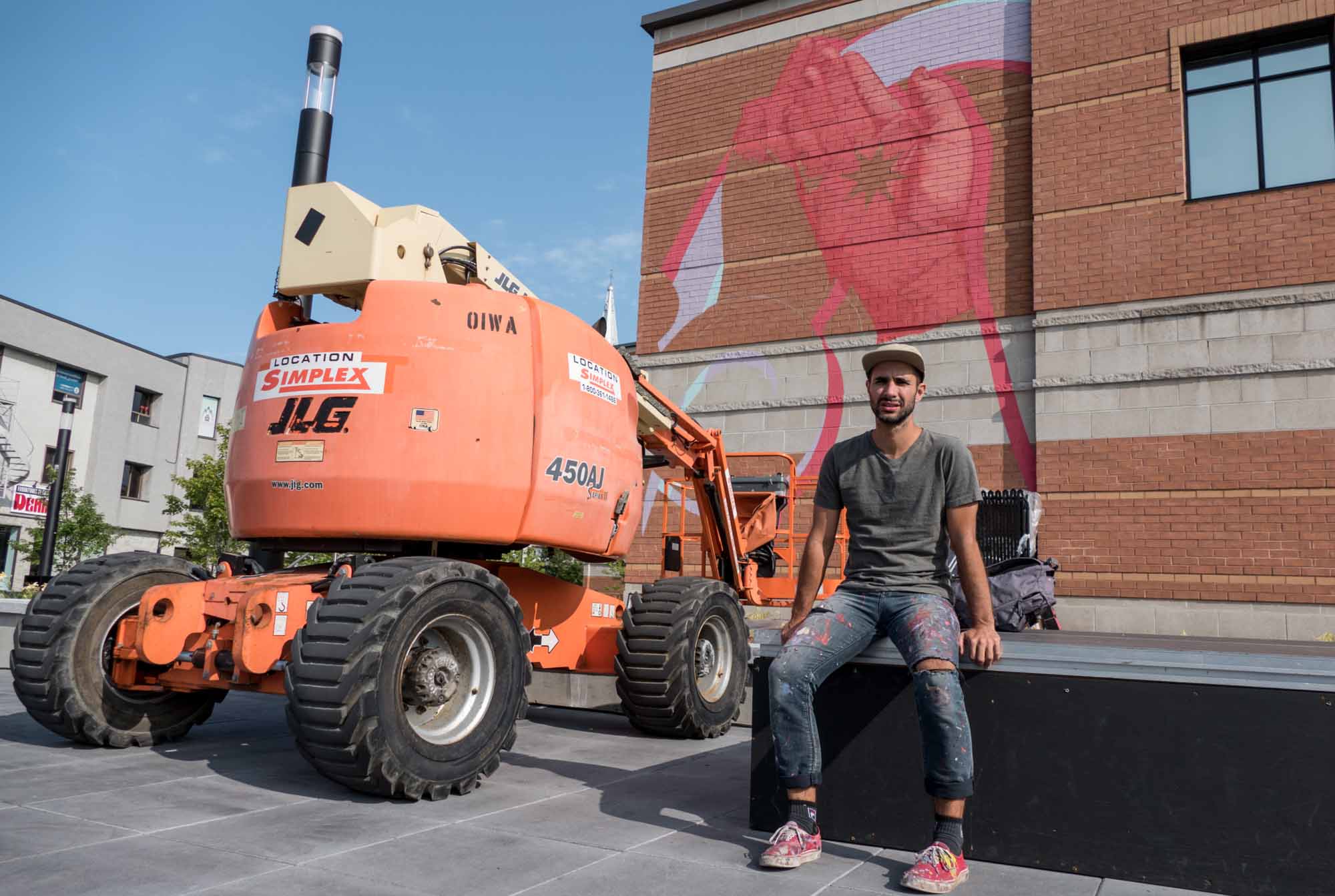 Kevin Ledo alors qu'il s'apprête à reprendre le travail sur la murale, le vendredi 25 août 2017 à la Place des festivités de Saint-Jérôme.