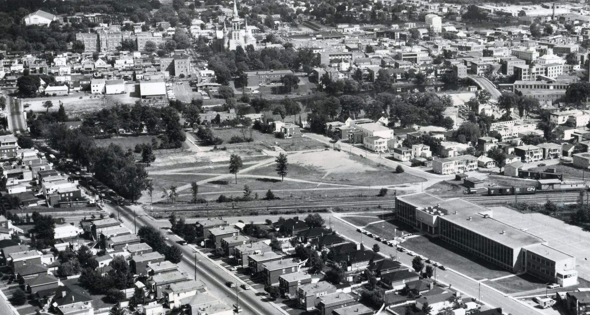 Image aérienne de l'école Mgr-Frenette et du terrain vacant après l’incendie du vieux collège, là où se trouvent aujourd’hui le palais de justice et l’édifice Athanase-David à Saint-Jérôme.