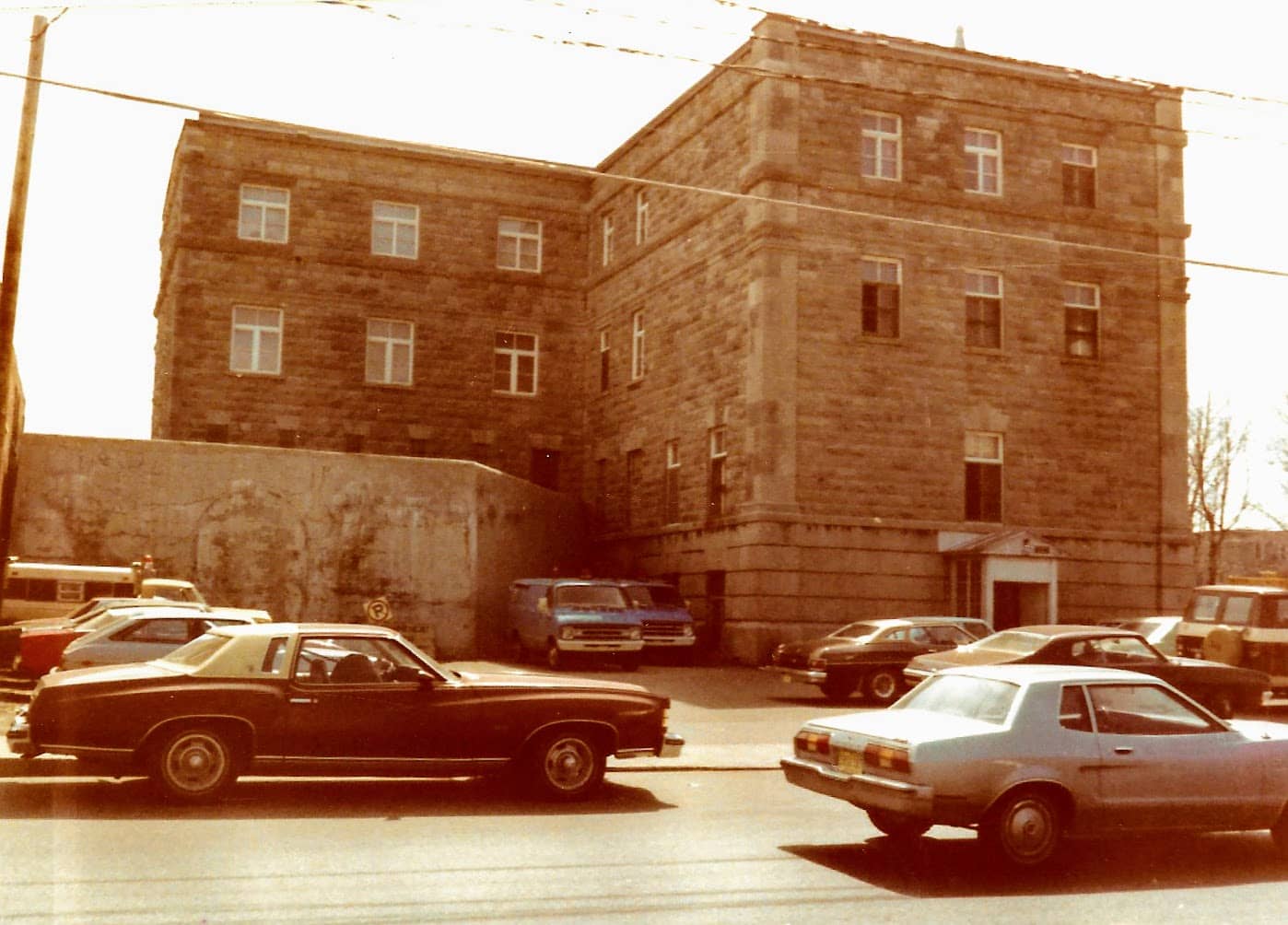 Un épais mur de béton à l'arrière du palais, vu de la rue Labelle.