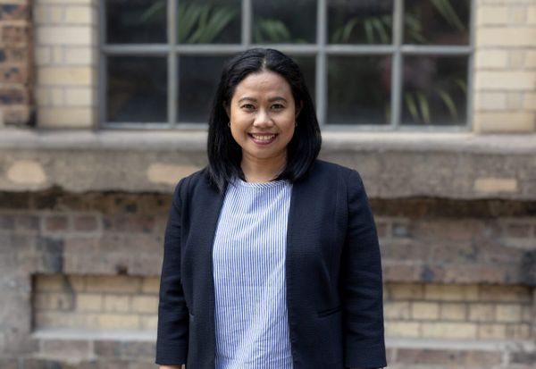 Hero image woman standing in front of brick wall Joyanne Coca