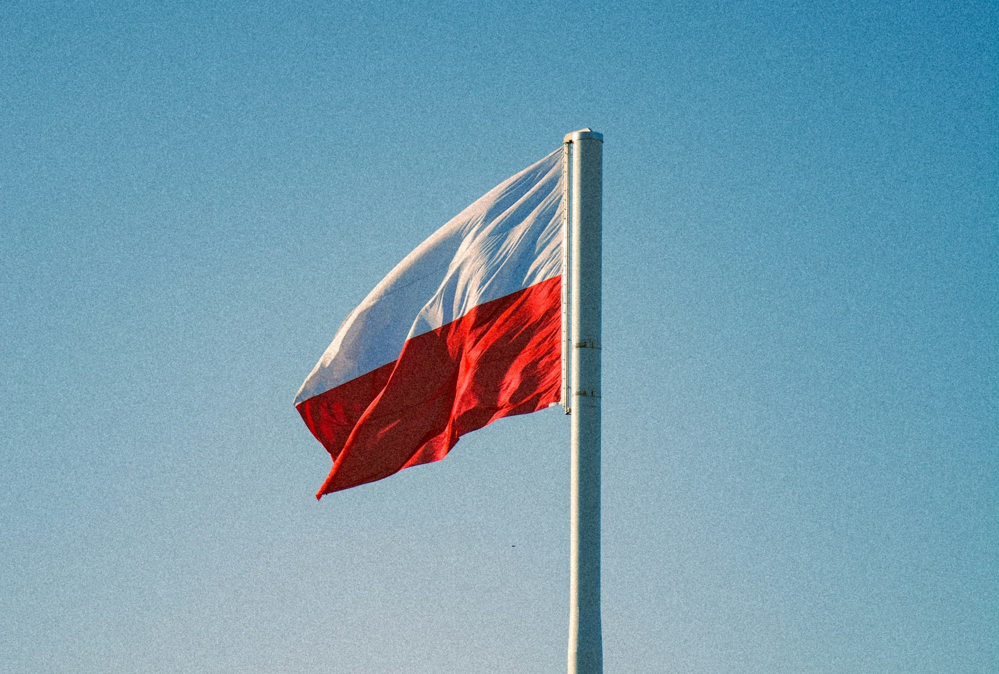 a red and white flag flying in the wind