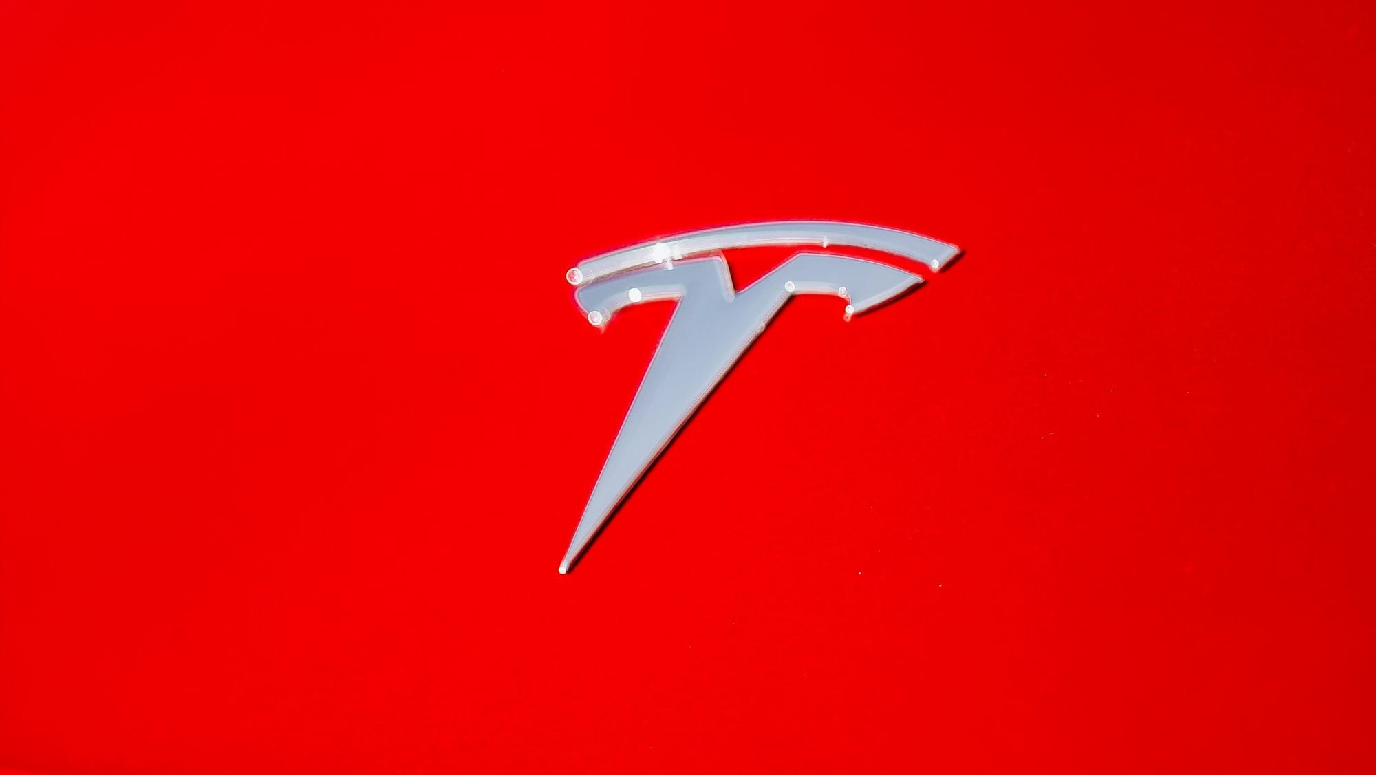Tesla logo, super close up view of an electric car hood