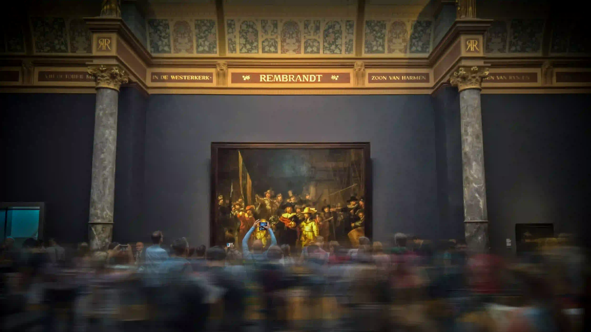 A motion-blurred crowd of tourists observing a grand Rembrandt painting in a museum, visually conveying the dizzying and claustrophobic pressure of modern aesthetic expectations.