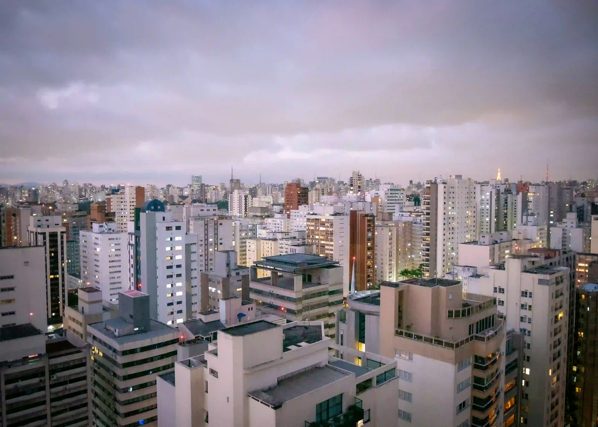 A dense, moody twilight view of São Paulo's skyline, showcasing the raw, densely packed architecture of the city devoid of outdoor advertising.