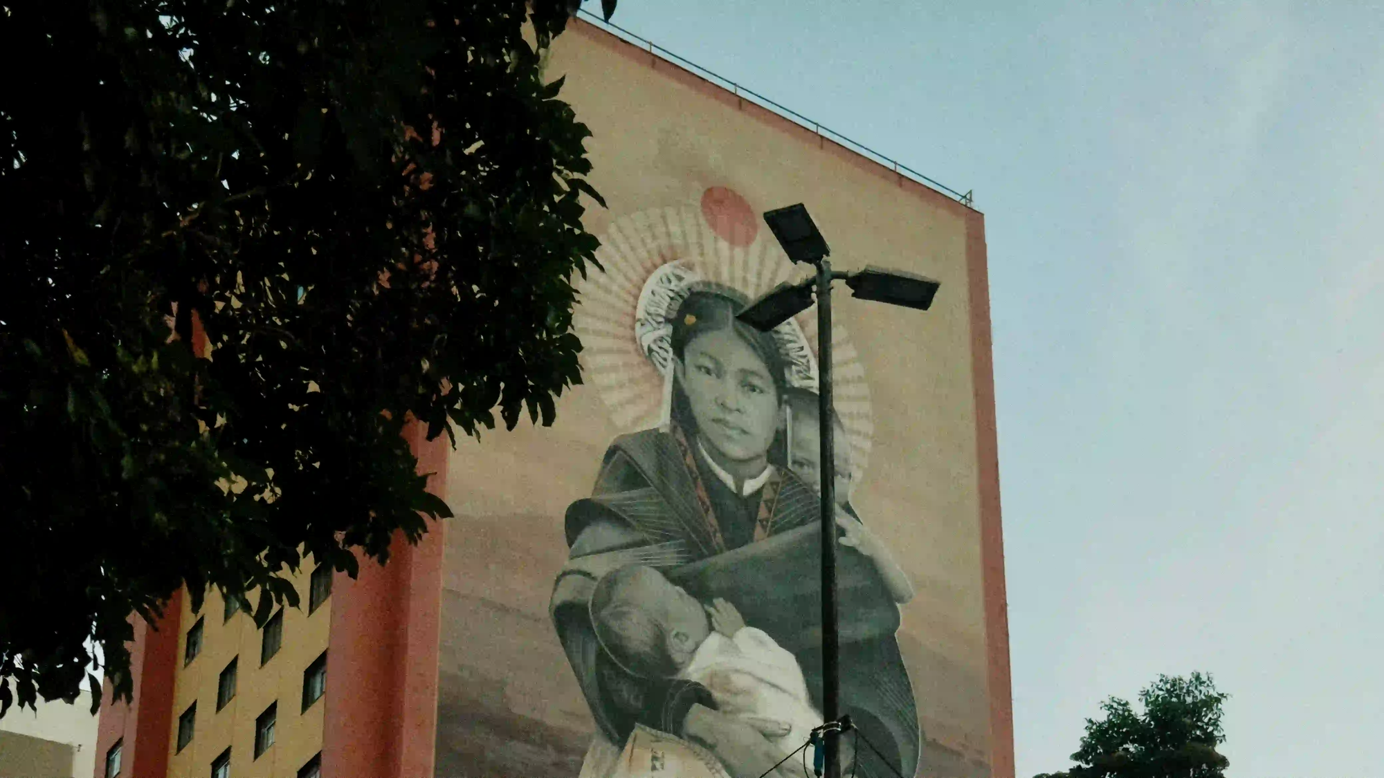 A monumental street art mural painted on a massive, windowless building facade in São Paulo, representing the city's authentic new visual identity after the corporate advertising ban.