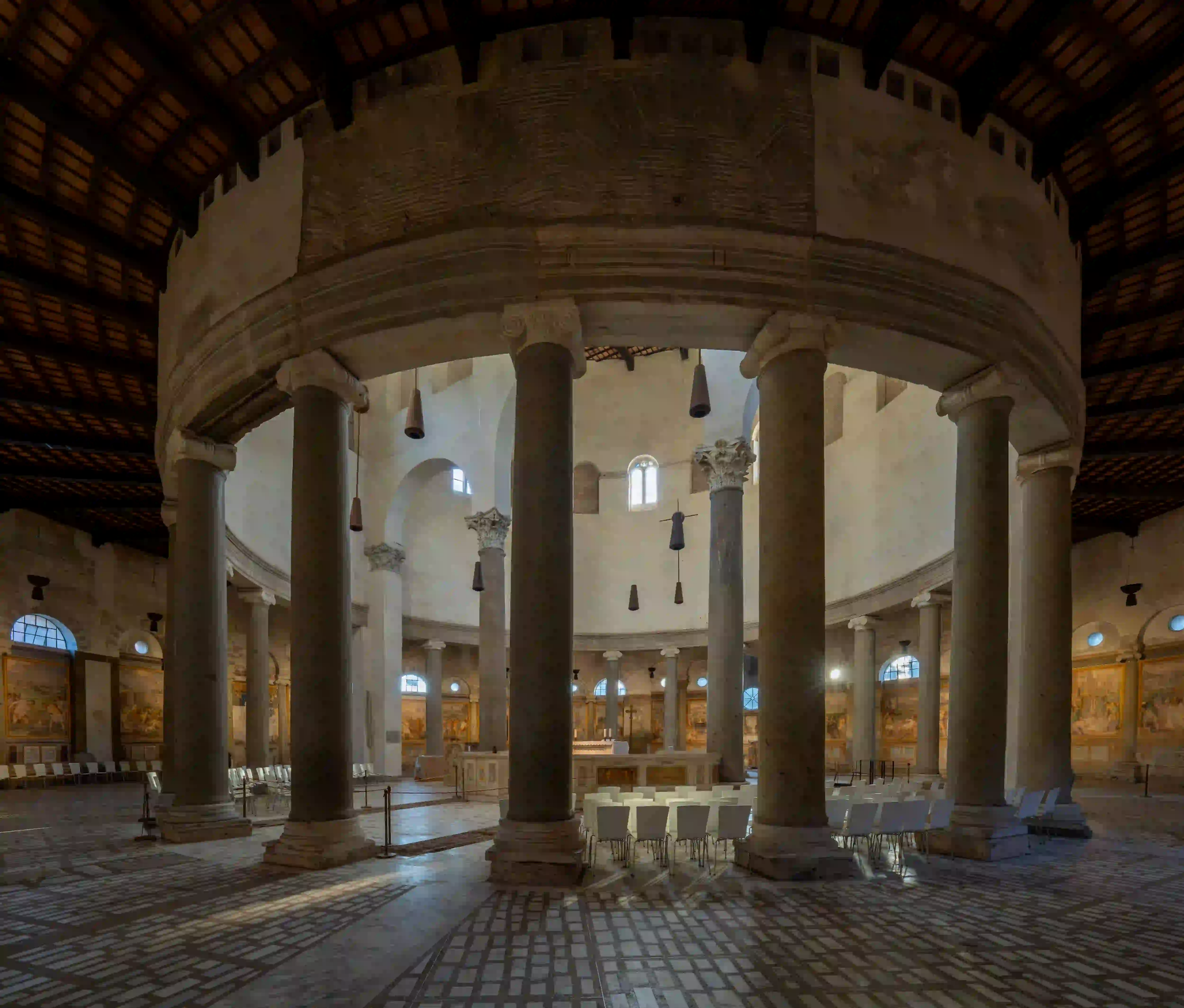 Wide interior view of Santo Stefano Rotondo in Rome, showing its ancient circular colonnade and the massive cylindrical void that dampens sound.