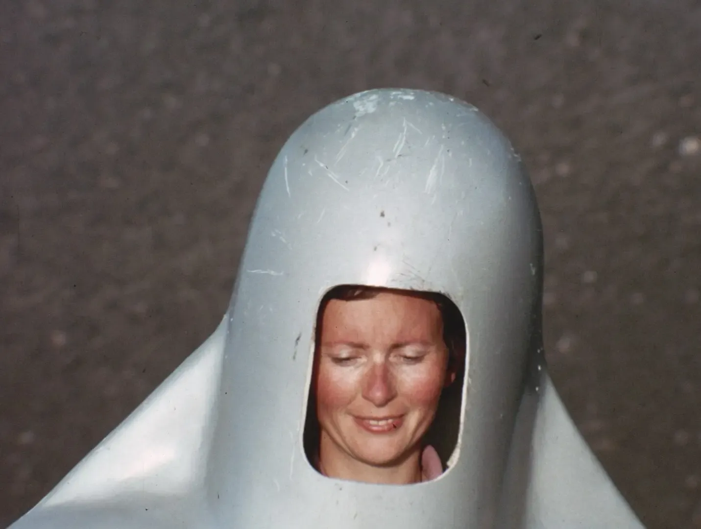 Close up of volcanologist Katia Krafft wearing a heavy silver aluminum and asbestos protective helmet.