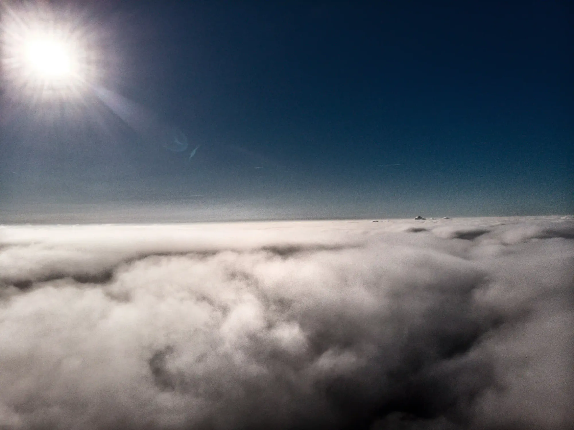 A low exposure view of the high altitude stratosphere showing a thick layer of atmospheric haze under a bright sun.