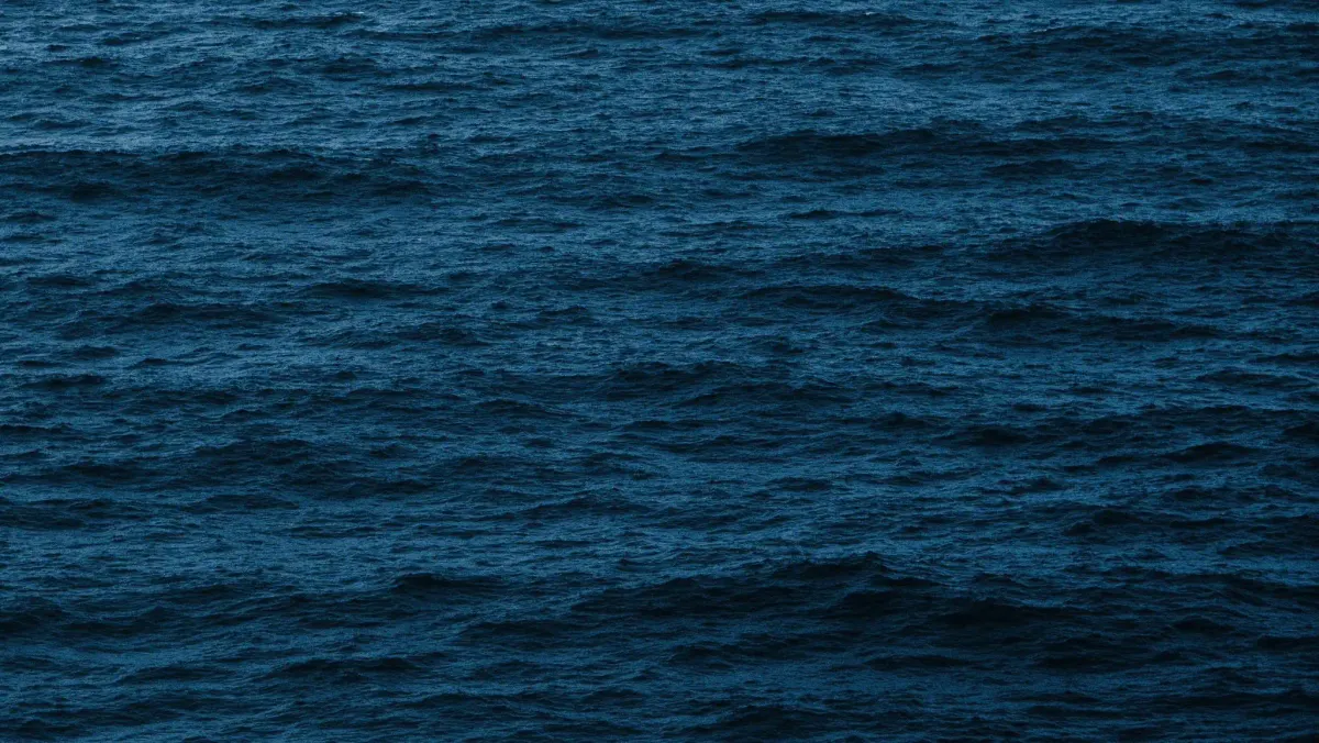 A vast expanse of deep dark blue ocean waves, reflecting the depth and tranquility of the natural world.