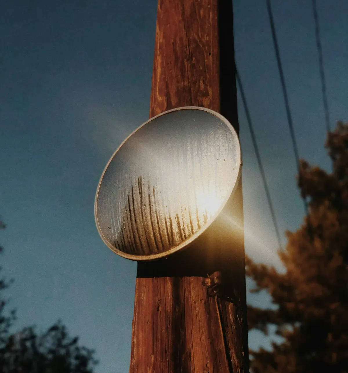 A foggy outdoor mirror reflecting bright sunlight against a dark blue sky, symbolizing climate intervention.