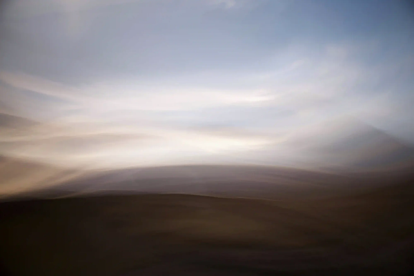 Abstract motion-blurred landscape in muted earthy tones representing the fading memory of a dying planet.