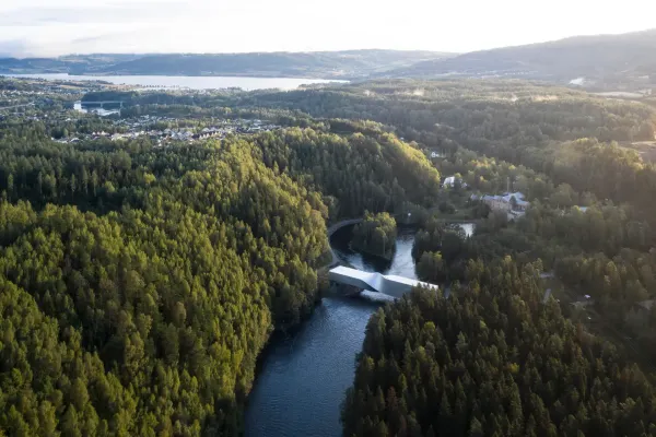Aerial view of The Twist gallery spanning the Randselva river surrounded by a Norwegian forest at Kistefos Museum.