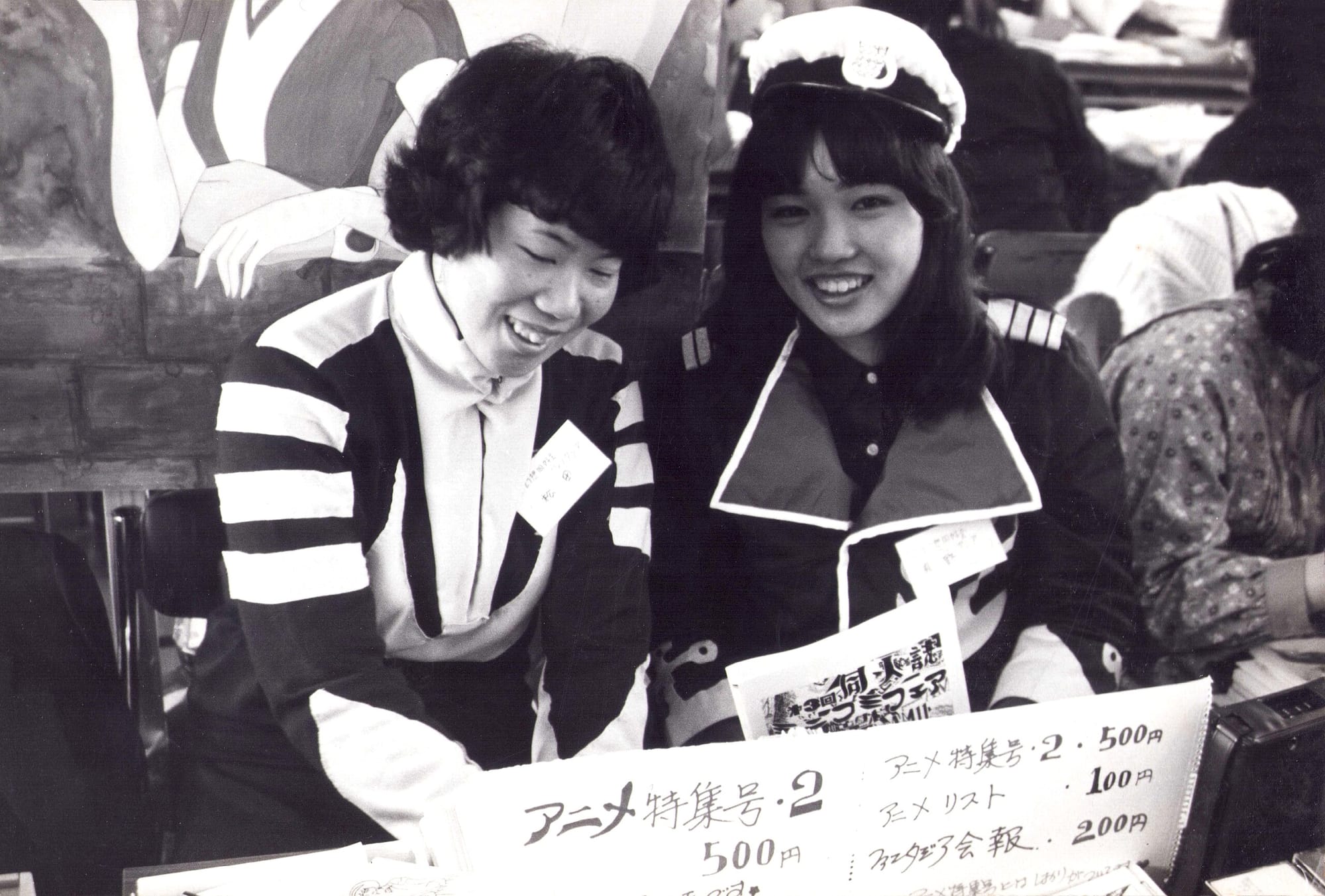 Two women in costumes smile for the camera.