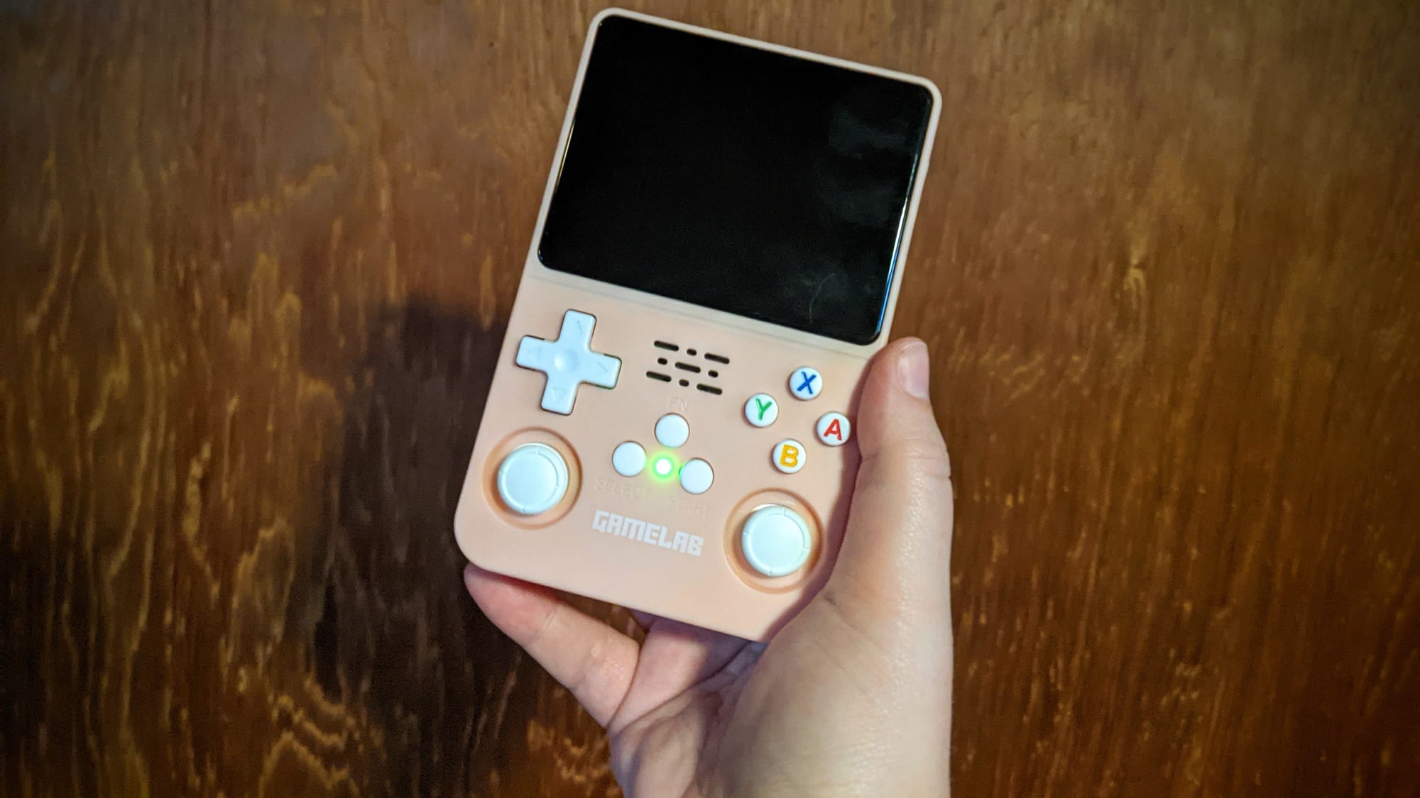 A Gamelab R36S console in pink with white buttons.