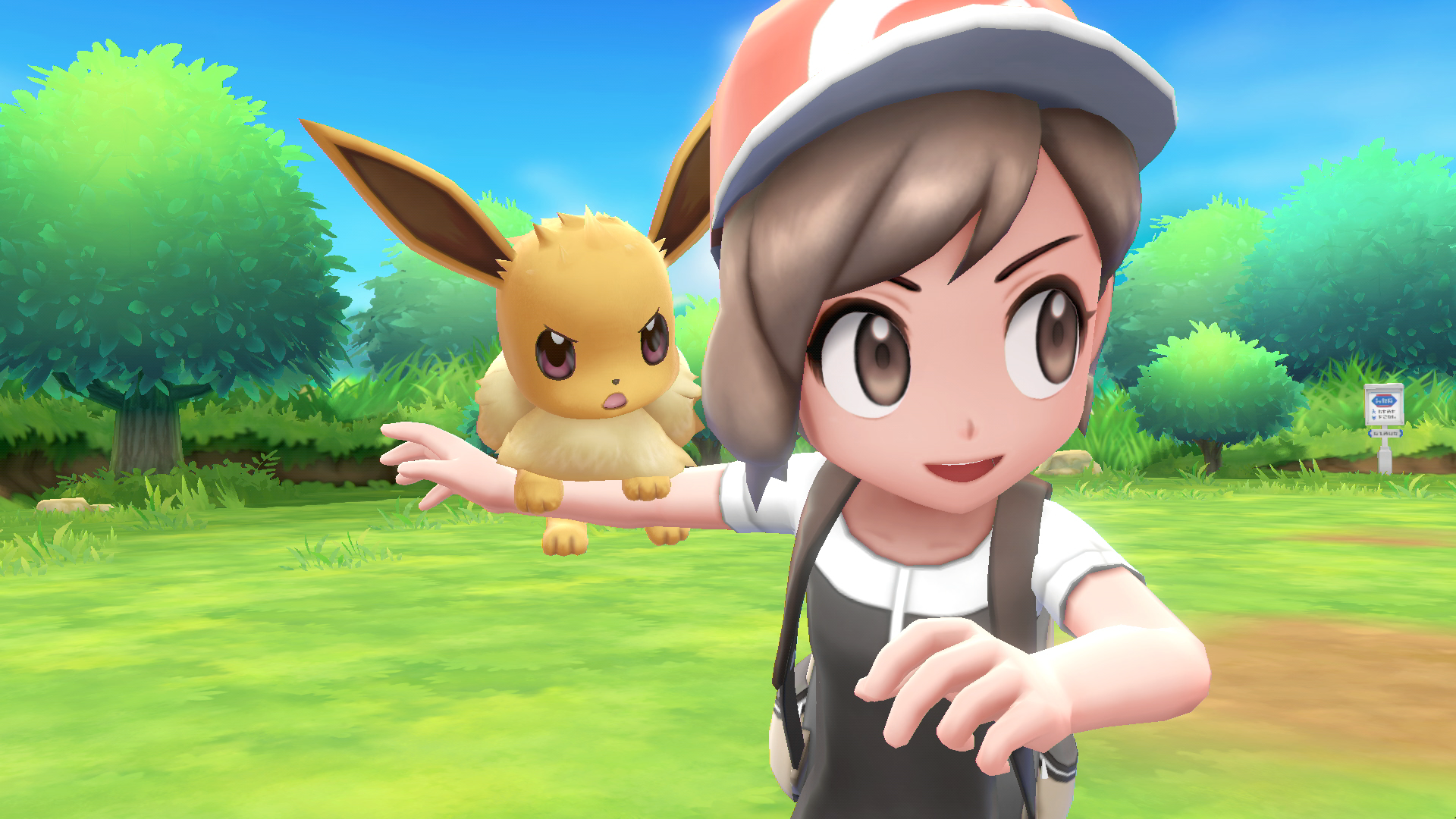 Screenshot from Pokemon Let's Go Eevee; a trainer holds her Eevee companion on her arm as they prepare to battle.