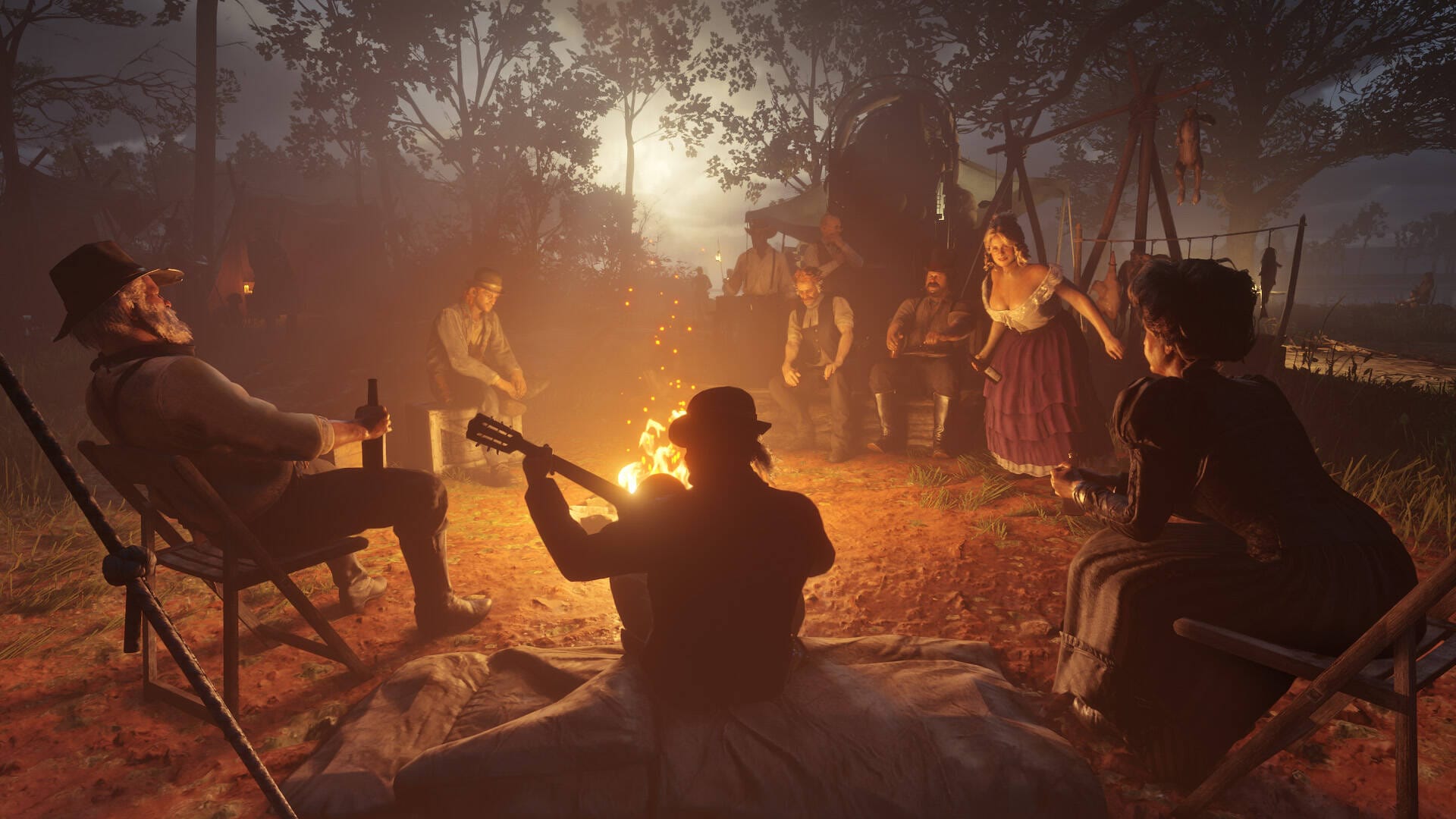 Red Dead Redemption 2 Screenshot. Dutch's gang gathers by the fire at night for music and merriment.