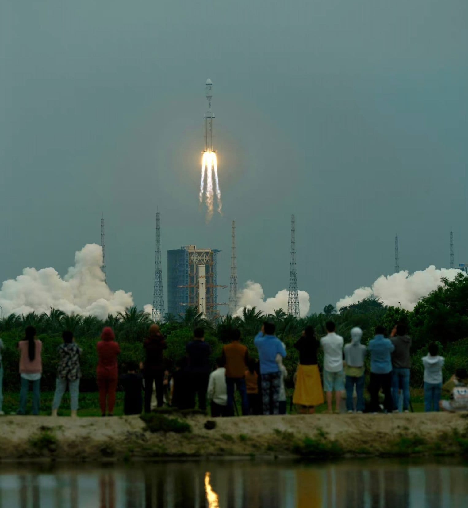 The Long March 8 Y3 lifting off from Launch Complex 2 in the background with a crowd watching in the foreground. ©黑白猫名字被占用 via Wu Lei