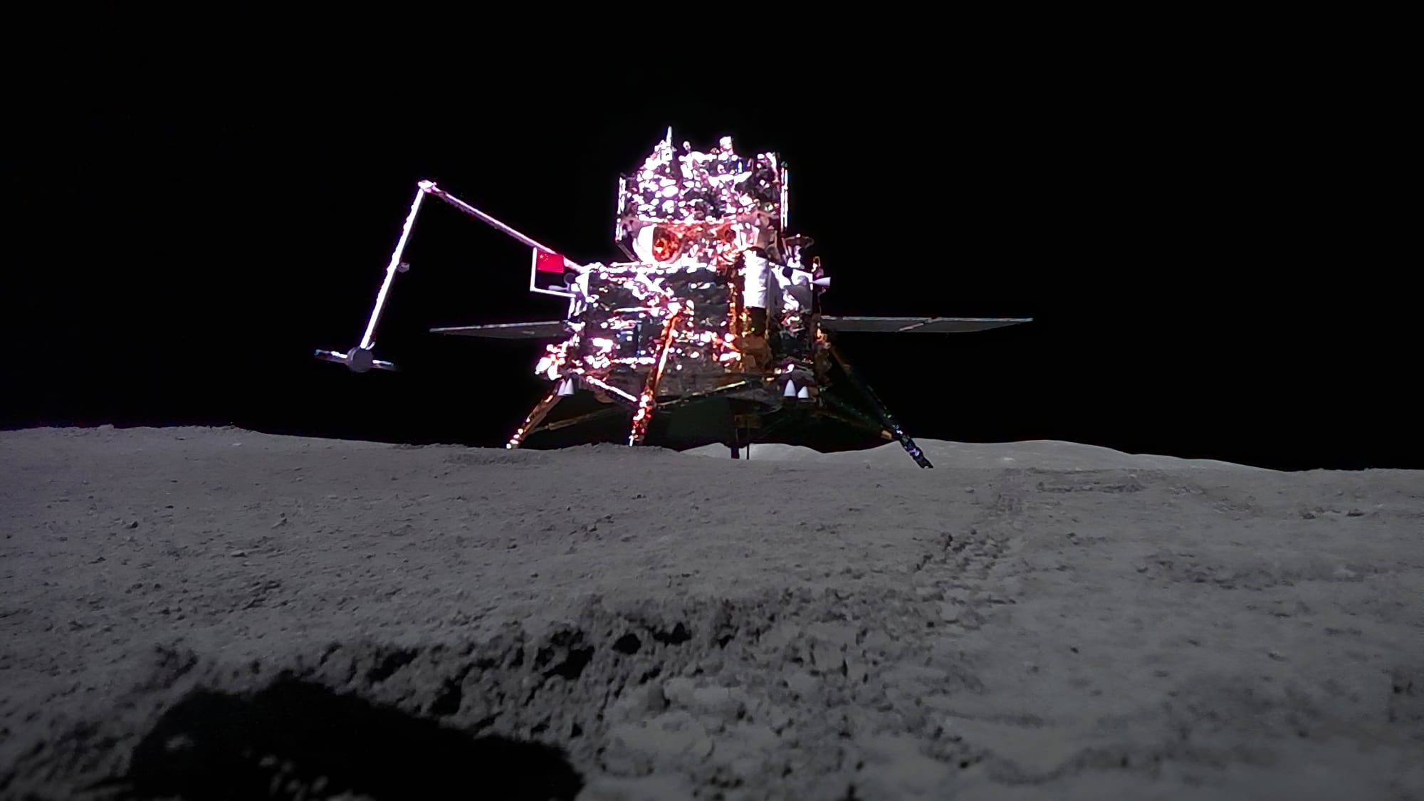 The Chang'e 6 lander on the lunar surface with the ascender on top, with the photo captured by a small rover. ©China National Space Administration