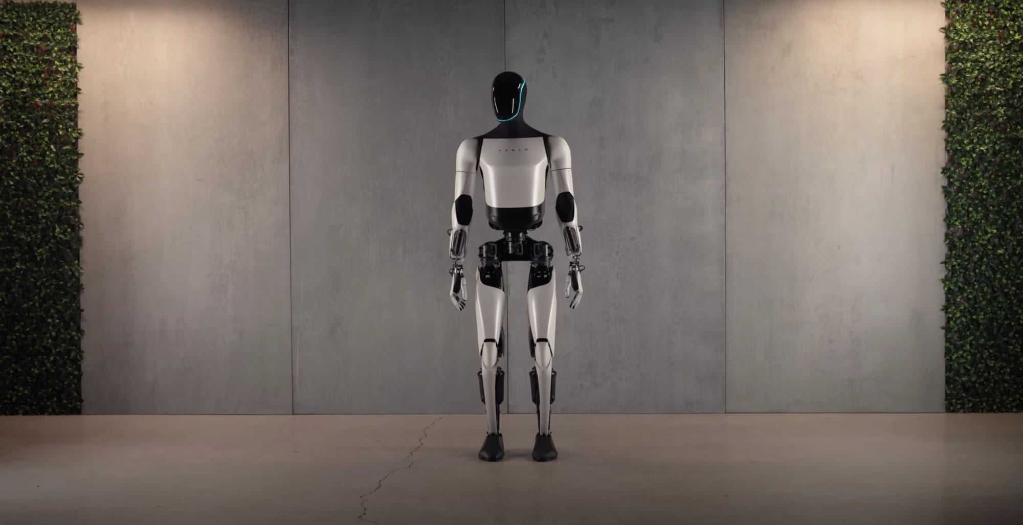 Tesla Optimus Gen 2 robot standing in front of a wall during a showcase event