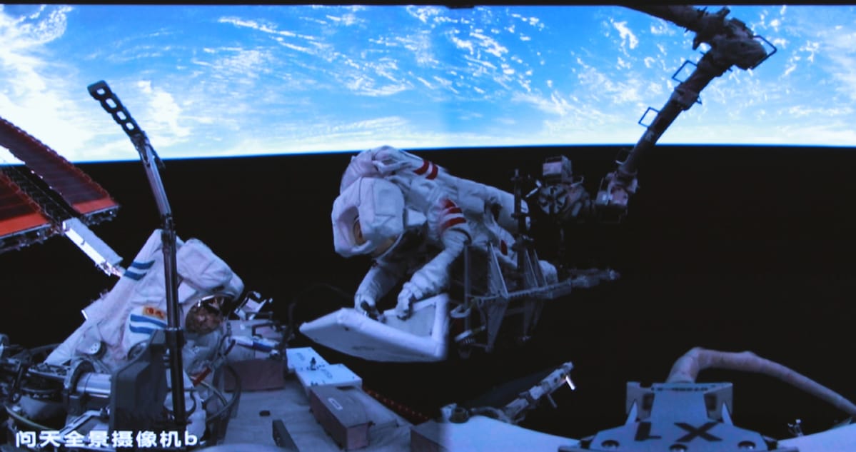 Chen Dong and Chen Zhongrui moving a space debris protection panel. ©China Manned Space Agency