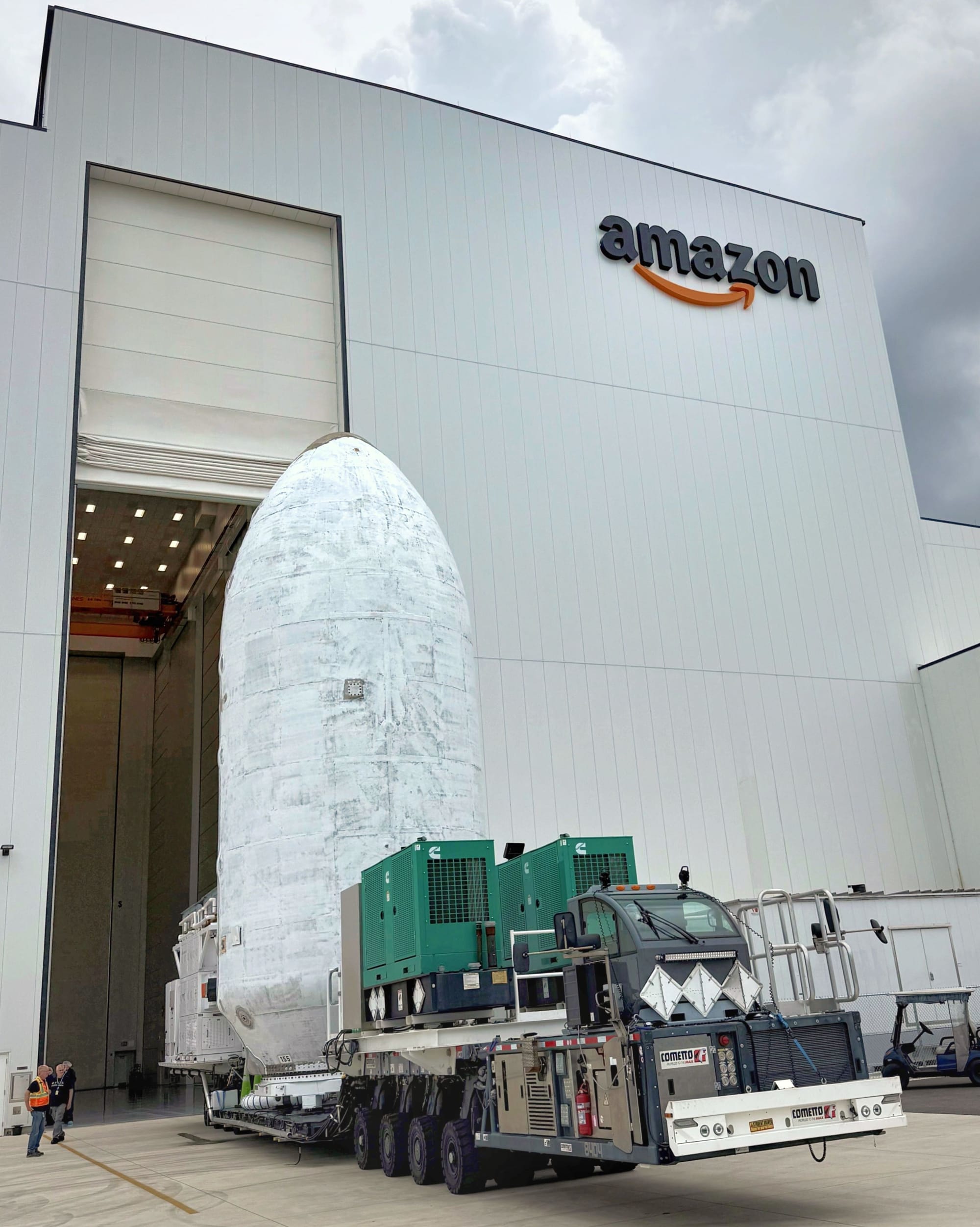 Falcon 9's fairing with 24 Kuiper satellites inside departs Amazon's spacecraft integration facility in Florida. ©Amazon