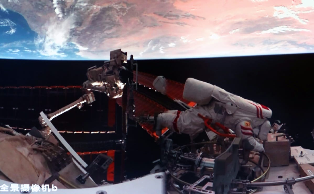 Chen Zhongrui preparing to detach his harness from the Wentian module after being secured to Tiangong's robotic arm.