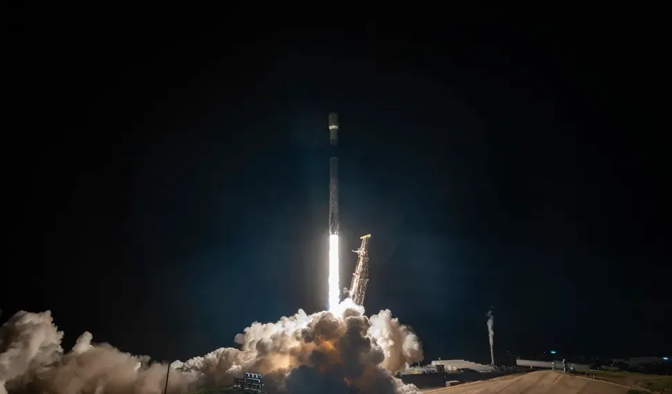 A SpaceX Falcon 9 rocket roars off the launch pad at night carrying dozens of payloads to a sun-synchronous orbit 