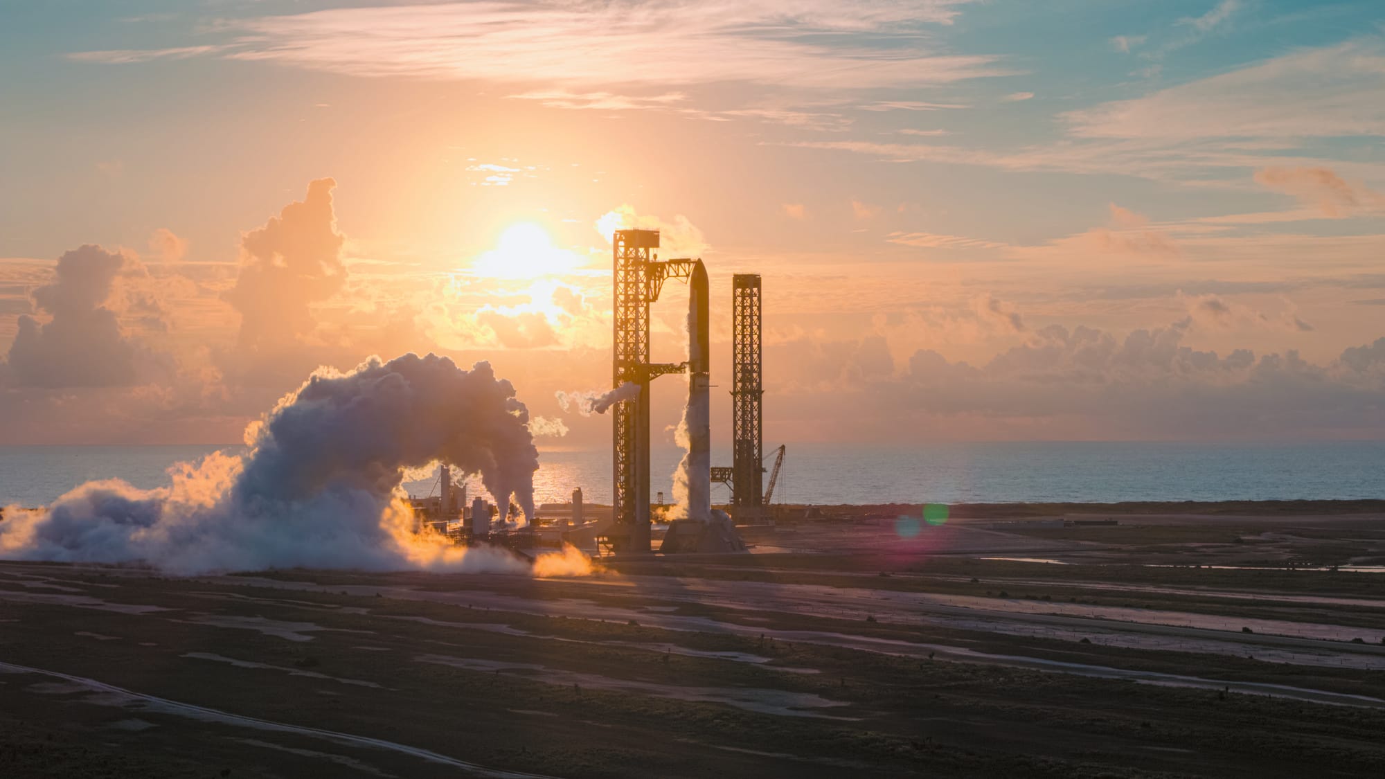 SpaceX's Starship-Superheavy rocket seen imaged on the launch pad with the rising Sun and Texas coast in the background
