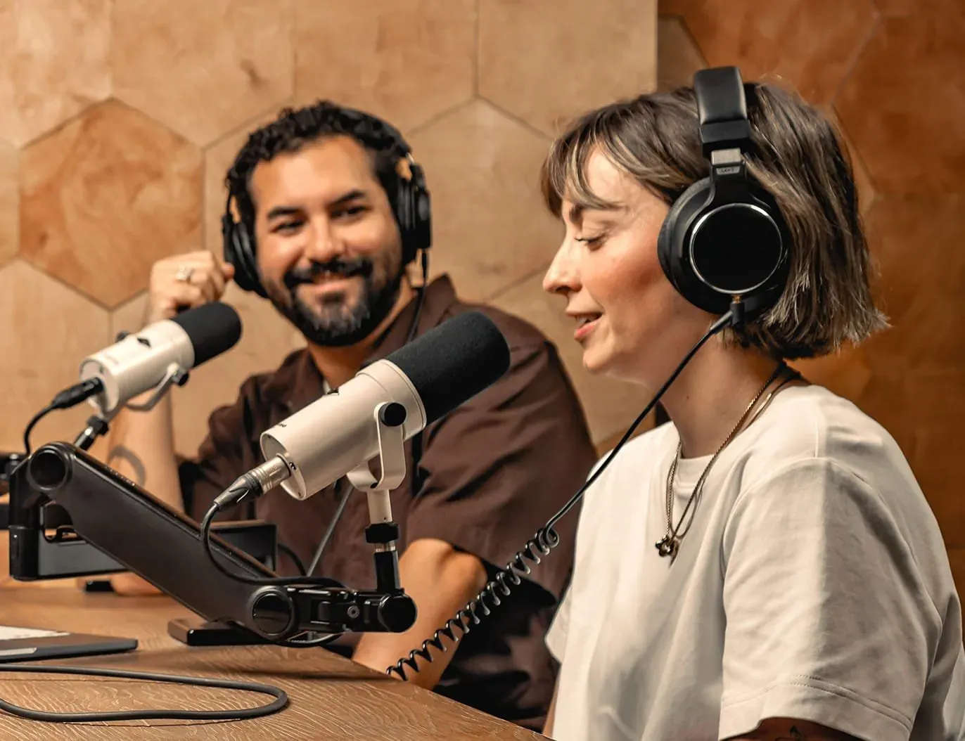 兩位主持人戴著耳機，各自對著麥克風錄 Podcast
