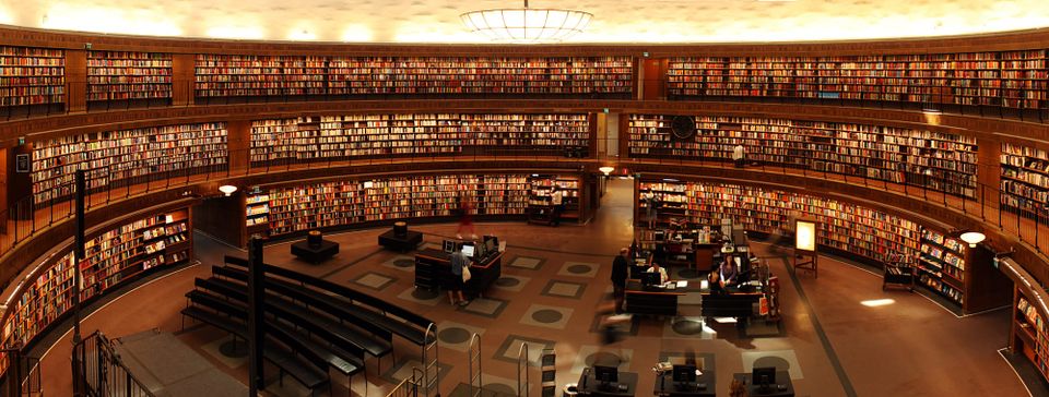 Image: wide-angle photo of the inside of a three-story library